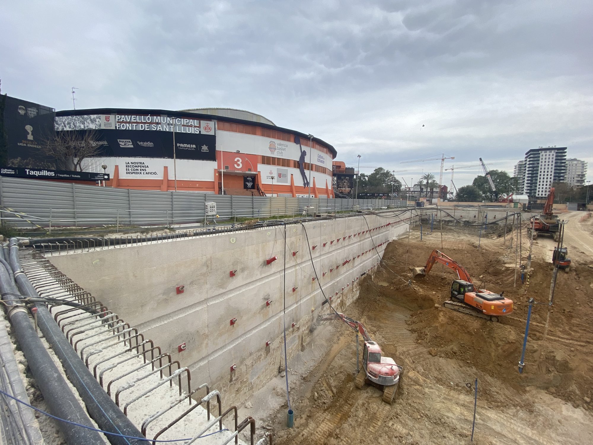 Excavación profunda contenida con muro pantalla anclado en el Parking General del Roig Arena (Valencia), con el recinto al fondo.